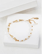 Vintage-gold sterling silver bracelet with natural pearls, polished beads and tapered metal elements arranged asymmetrically.