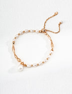 Vintage-gold sterling silver bracelet with elongated natural pearls, sculptural metal sections and a hanging drop-shaped pearl.