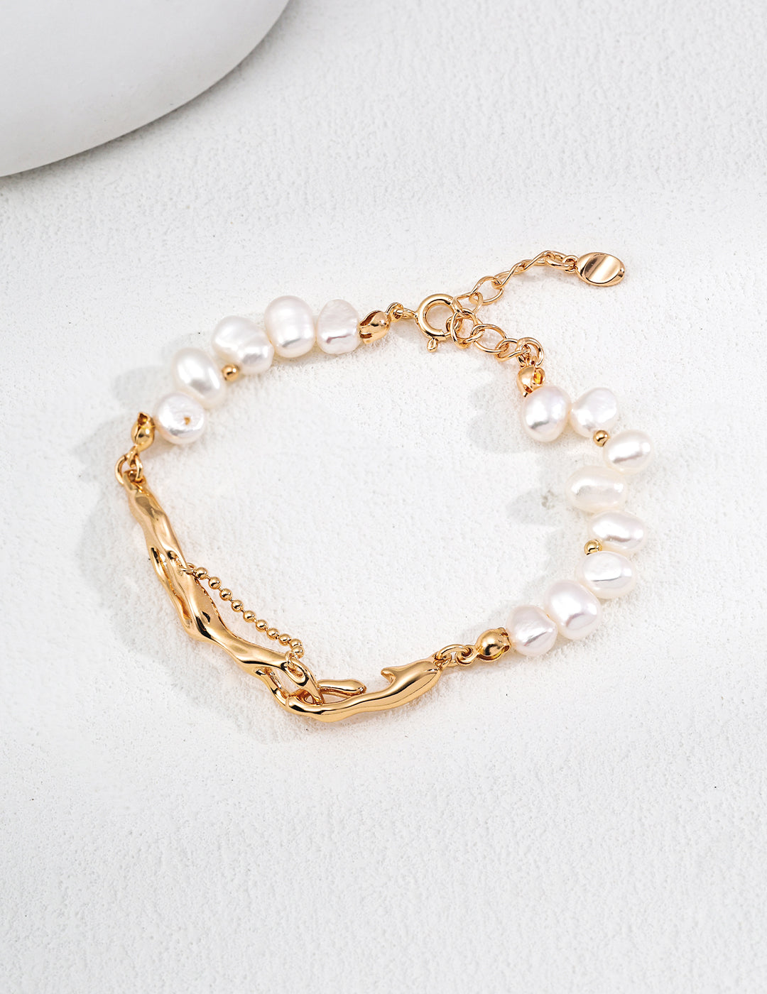 Vintage-gold sterling silver bracelet with irregular natural pearls, fluid-shaped metal elements and a fine bead-chain detail.