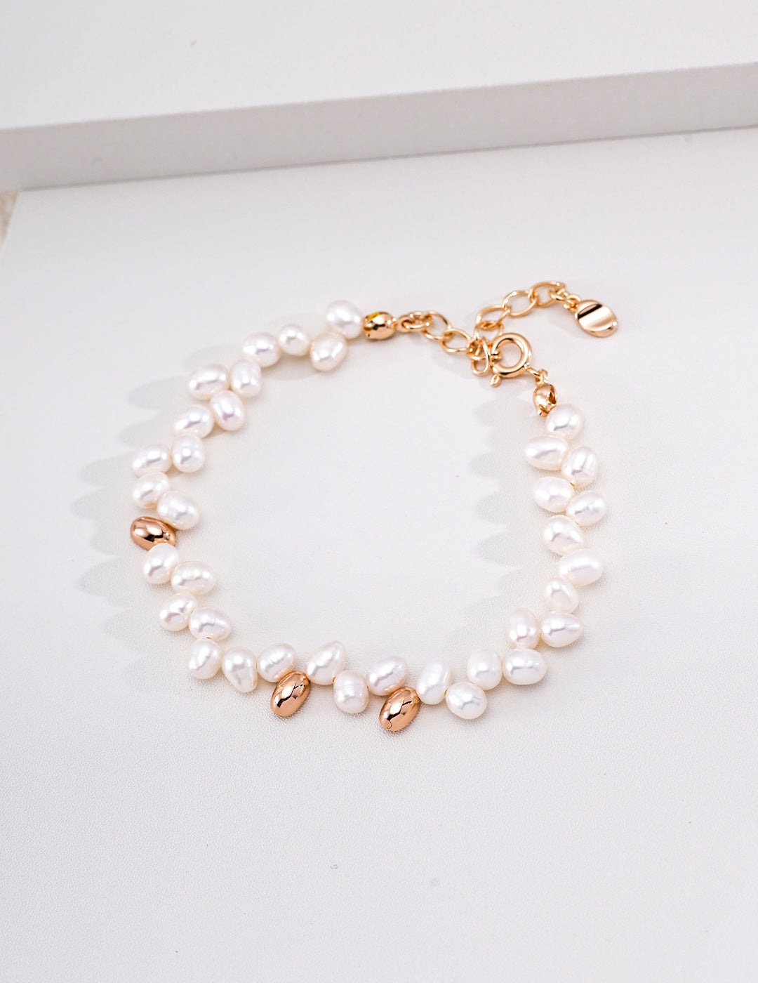 Vintage-gold sterling silver double-strand bracelet with offset rows of irregular natural pearls and polished metal details.