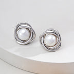 Vintage-gold sterling silver earrings with central natural pearls surrounded by overlapping curved metal bands.