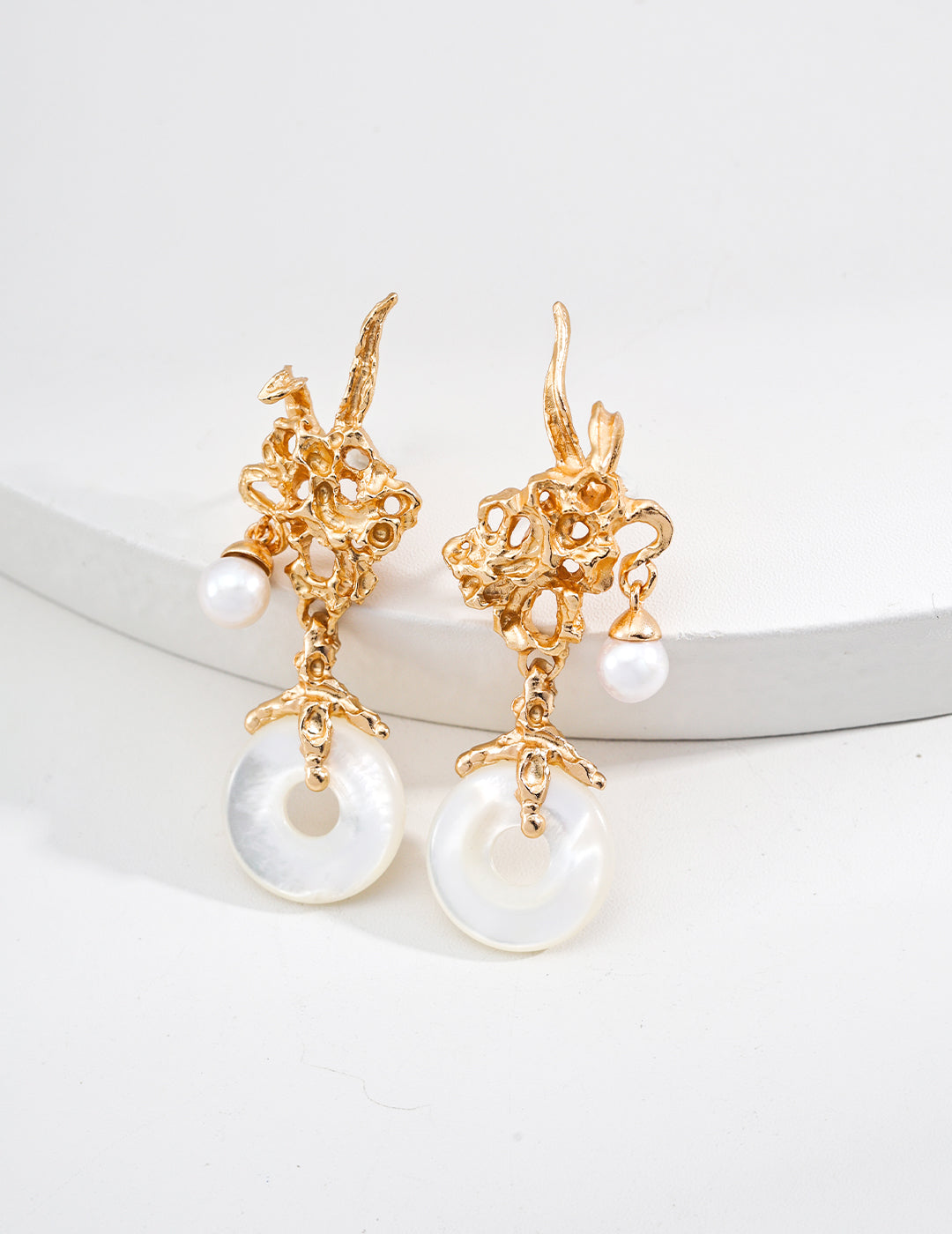 Vintage-gold sterling silver drop earrings with irregular openwork forms, suspended natural pearls and circular mother-of-pearl elements.