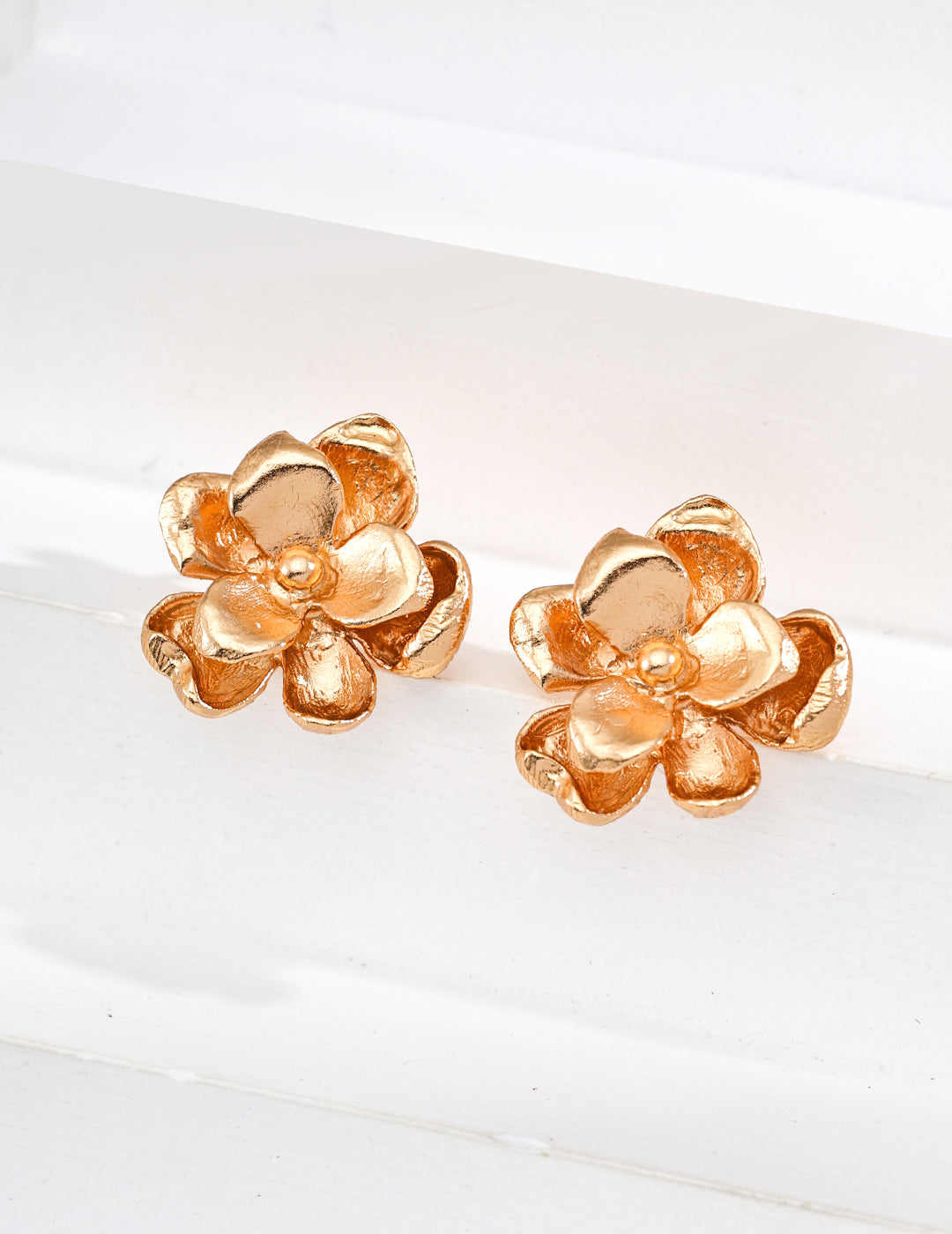Vintage-gold sterling silver floral stud earrings with two layers of irregular textured petals and a small metal center.