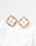 White-gold sterling silver stud earrings with four white mother-of-pearl petals, cubic zirconia accents and a softly squared frame.
