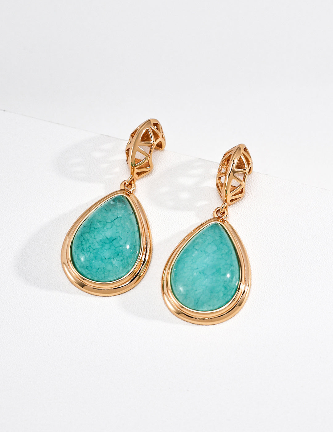 Sterling silver teardrop earrings with interchangeable stone and shell details in an elongated sculptural setting.