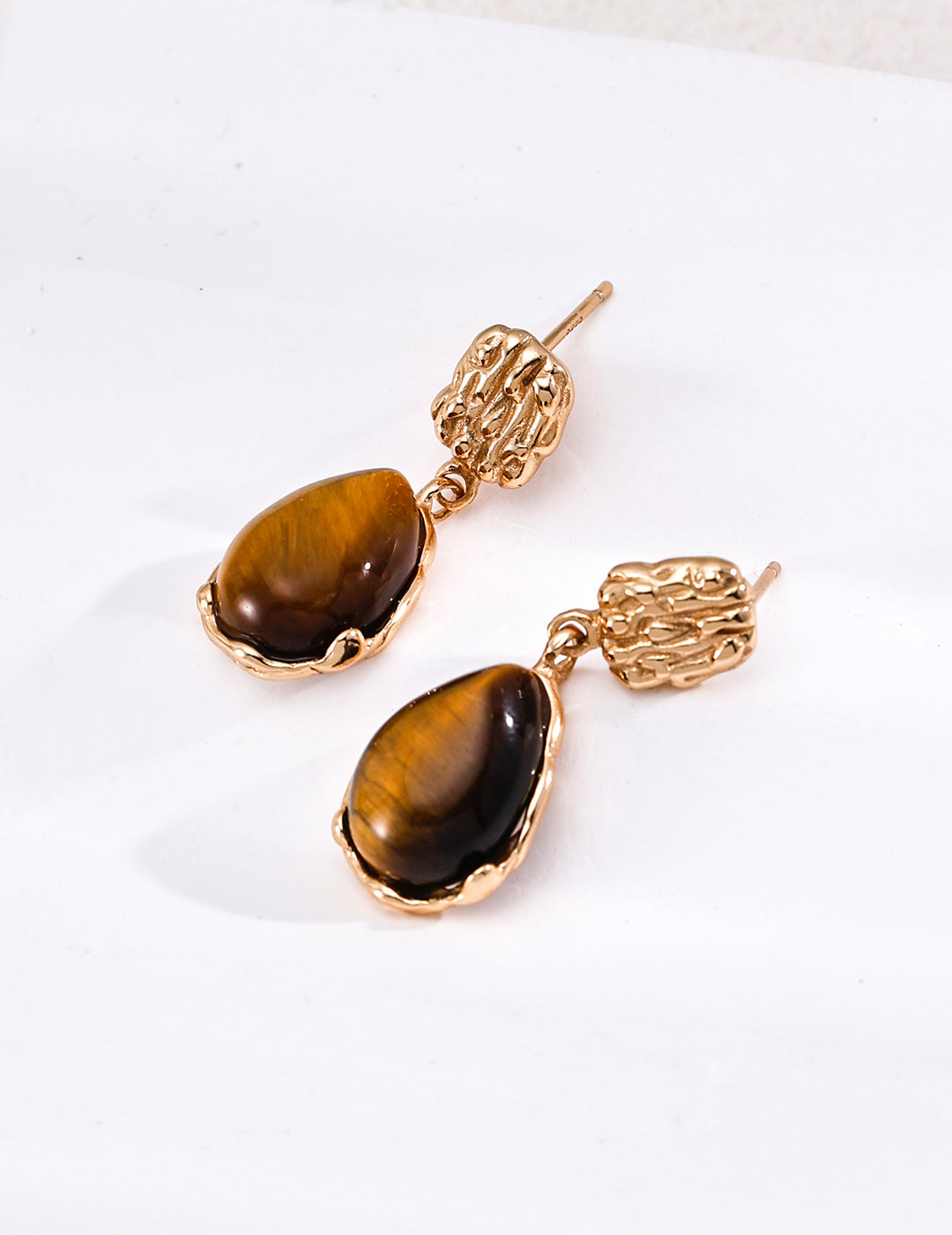 Vintage-gold sterling silver drop earrings with mother-of-pearl centers, textured openwork studs and irregular sculptural surrounds.