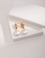 Vintage-gold sterling silver drop earrings with suspended natural baroque pearls.
