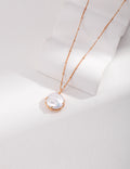 Vintage-gold sterling silver necklace with natural pearl details and a sculptural pendant composition.