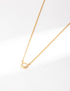 Vintage-gold sterling silver necklace with a small oval mother-of-pearl pendant in a softly irregular metal surround.