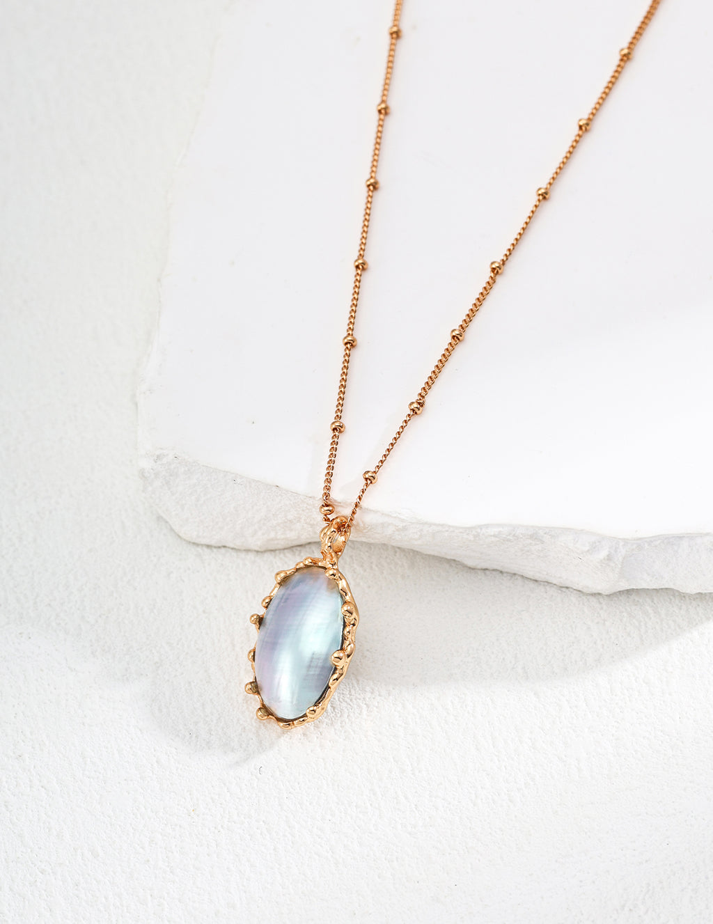 Vintage-gold sterling silver necklace with an oval iridescent Mabe pearl in an irregular sculptural metal surround.