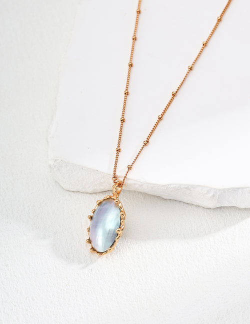 Vintage-gold sterling silver necklace with an oval iridescent Mabe pearl in an irregular sculptural metal surround.