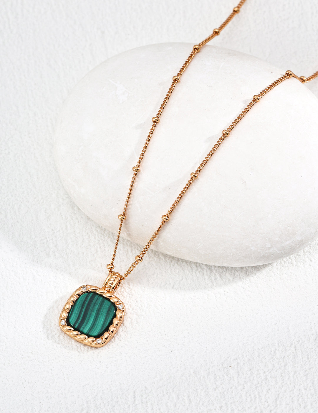 Vintage-gold sterling silver necklace with a rounded-square banded green malachite pendant, textured border and small zircon accents.