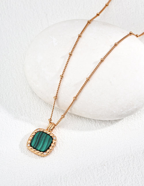 Vintage-gold sterling silver necklace with a rounded-square banded green malachite pendant, textured border and small zircon accents.