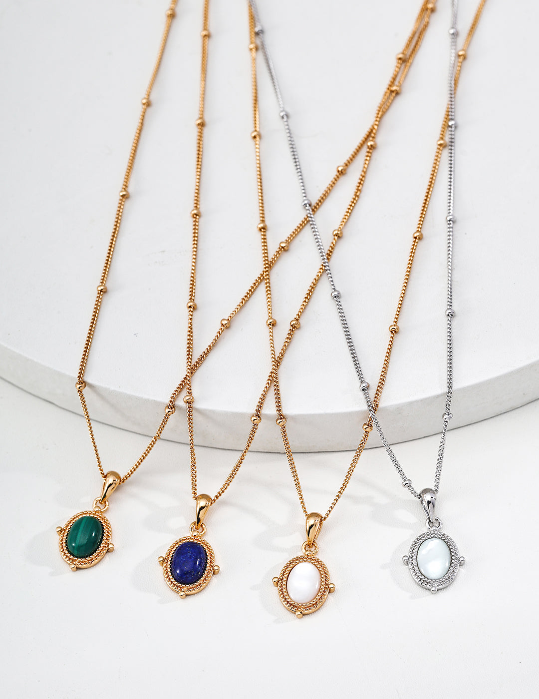 Vintage-gold sterling silver pendant necklace with an oval stone centerpiece in a softly irregular sculptural frame.