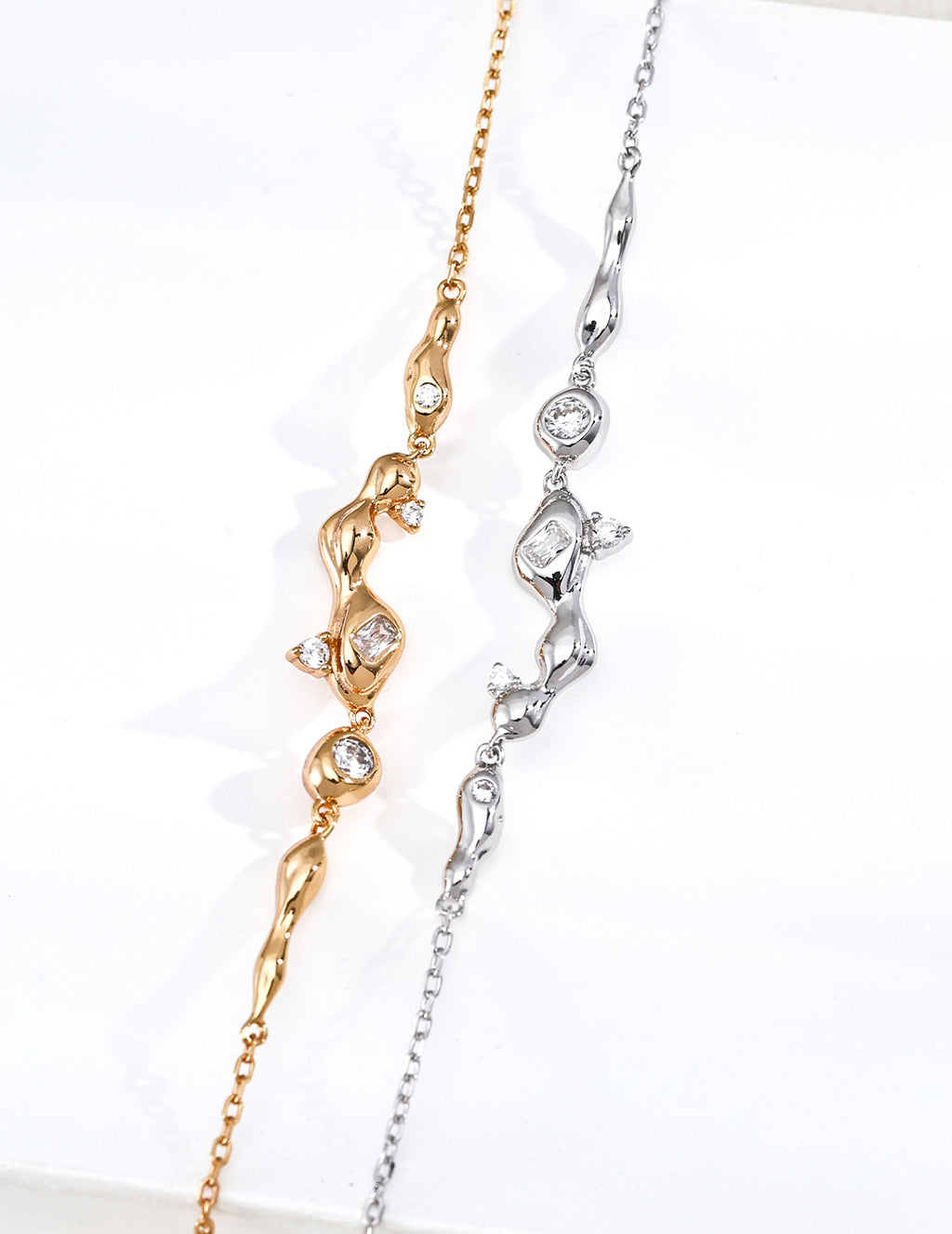 Vintage-gold sterling silver necklace with three cubic zirconia accents arranged asymmetrically among small fluid metal forms.