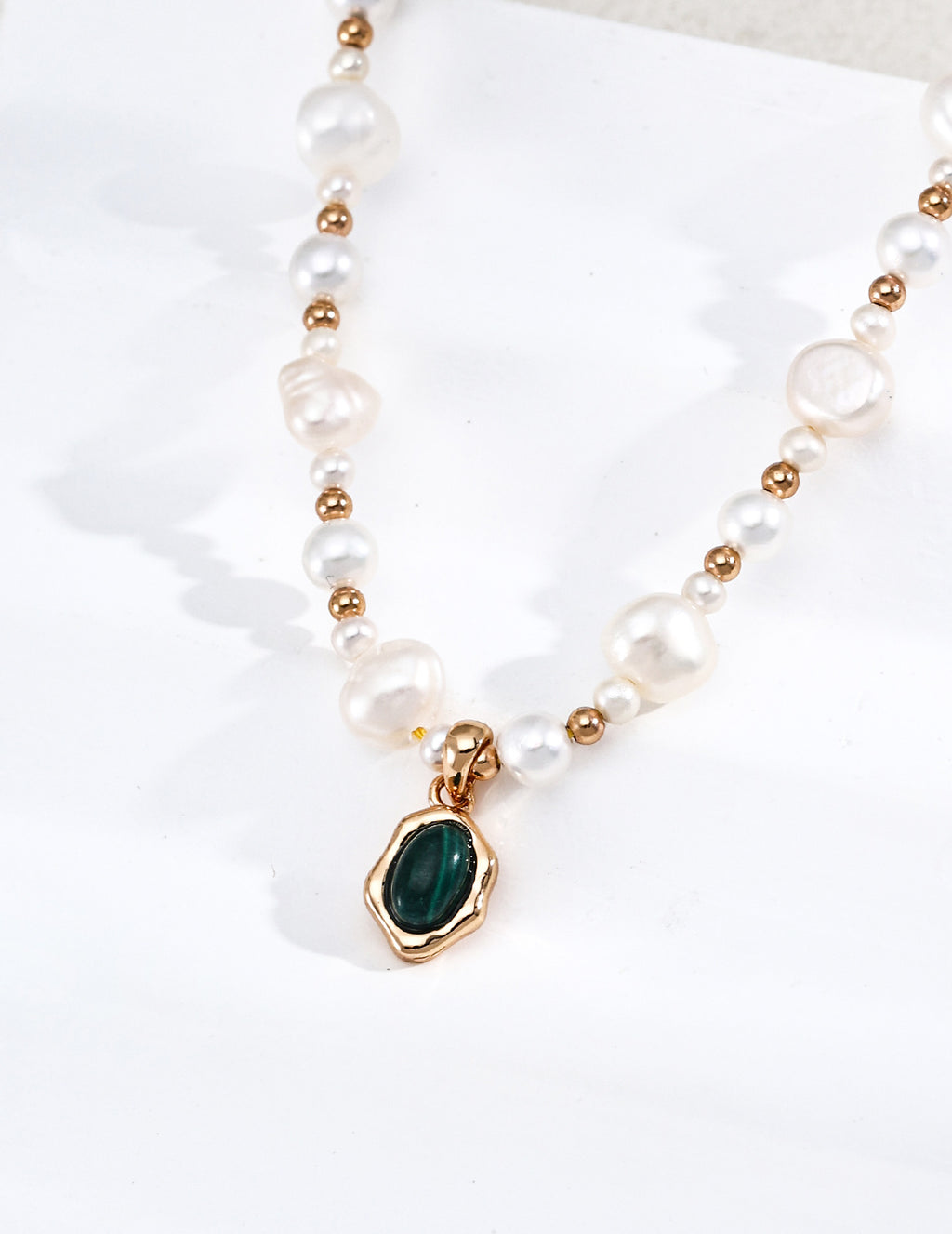 Vintage-gold sterling silver necklace with irregular white pearls, polished beads and an oval green malachite pendant in an undulating metal surround.