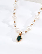 Vintage-gold sterling silver necklace with irregular white pearls, polished beads and an oval green malachite pendant in an undulating metal surround.